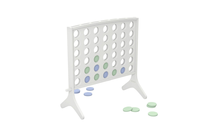 The Ledge Lounger Four In A Row is an oversized outdoor game featuring a vertical stand with circular holes. Light green and blue chips are strategically placed, with others scattered on the floor, resembling the classic four-in-a-row game setup.