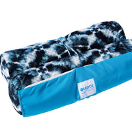 The Laze Hammock from Ledge Lounger is a rolled-up blue and black patterned blanket made with marine-grade fabrics. It includes a bright blue carrier bag with a white label, ideal for outdoor adventures.