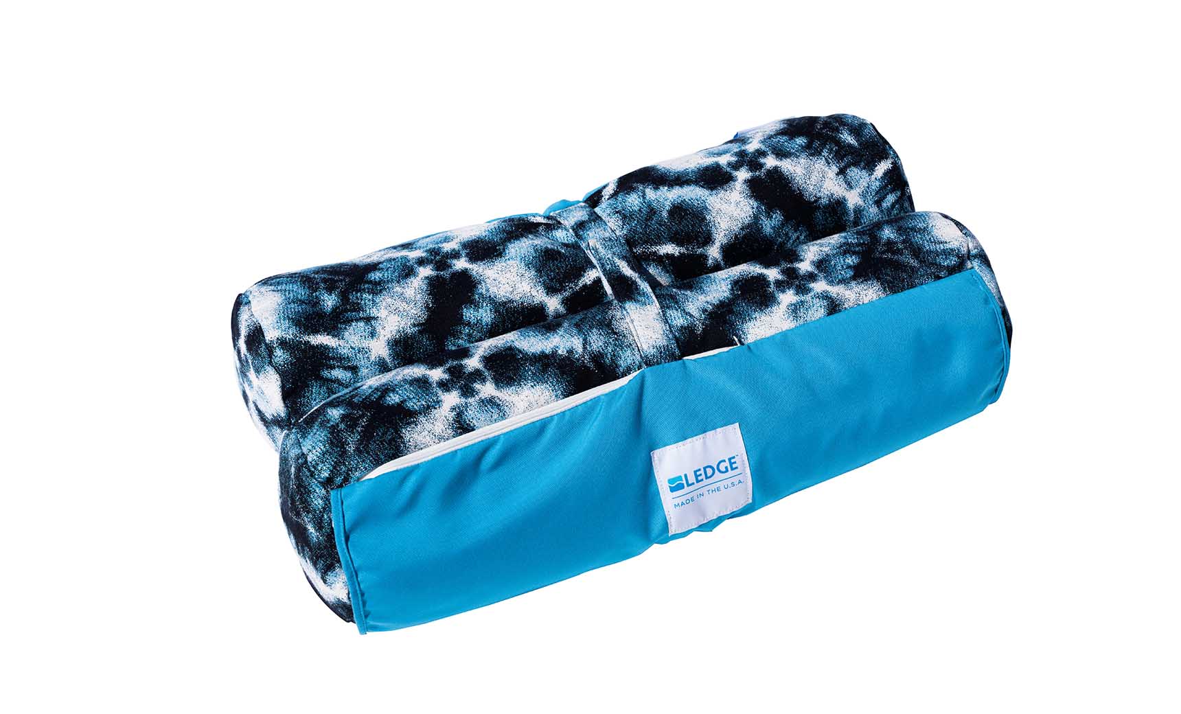 The Laze Hammock from Ledge Lounger is a rolled-up blue and black patterned blanket made with marine-grade fabrics. It includes a bright blue carrier bag with a white label, ideal for outdoor adventures.