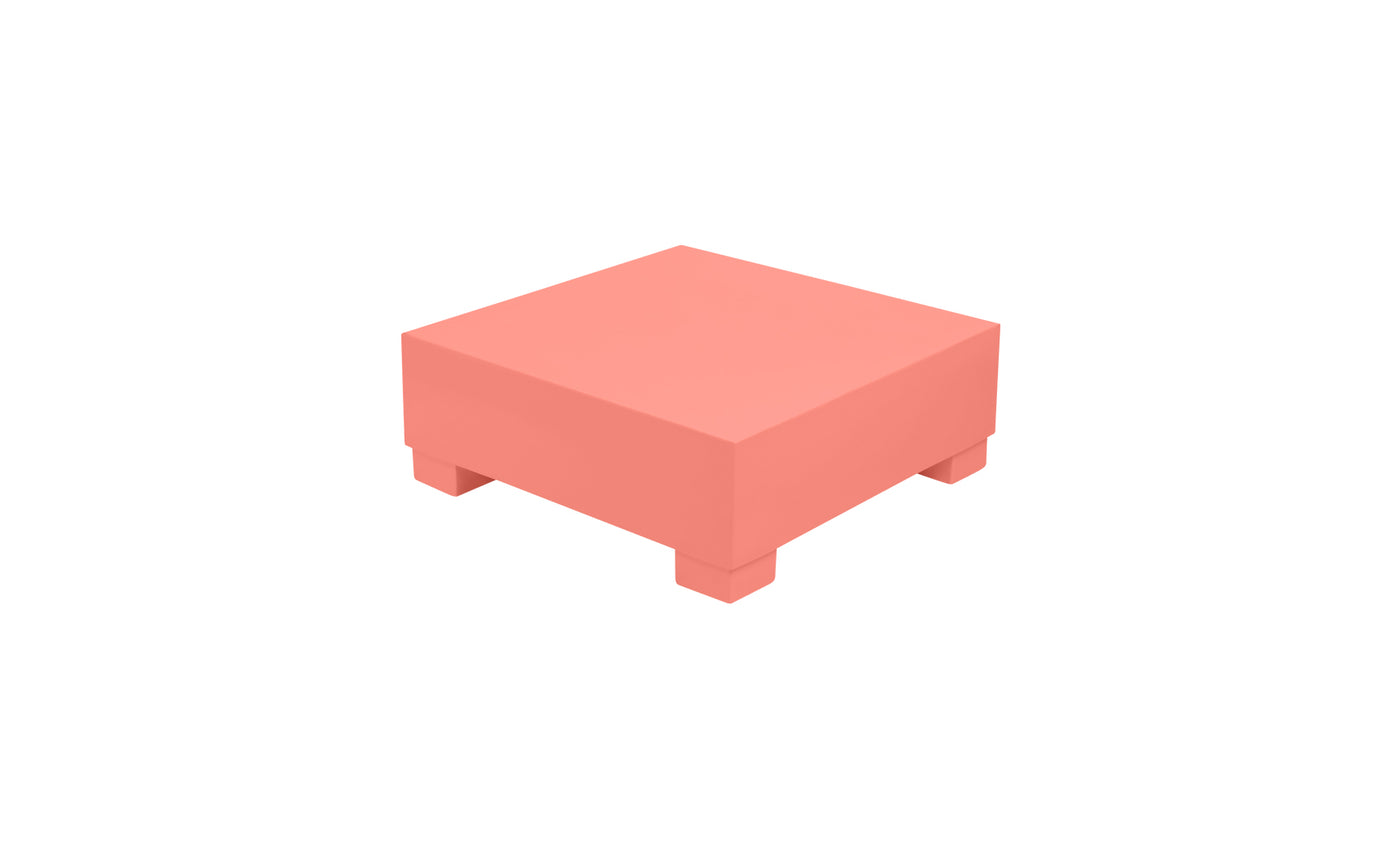 The Ledge Lounger Signature Coffee Table, a coral-colored square block with four short legs, offers minimalist elegance. Part of our Signature Collection, it’s perfect for stylish outdoor lounging by the pool, set against a plain white background.