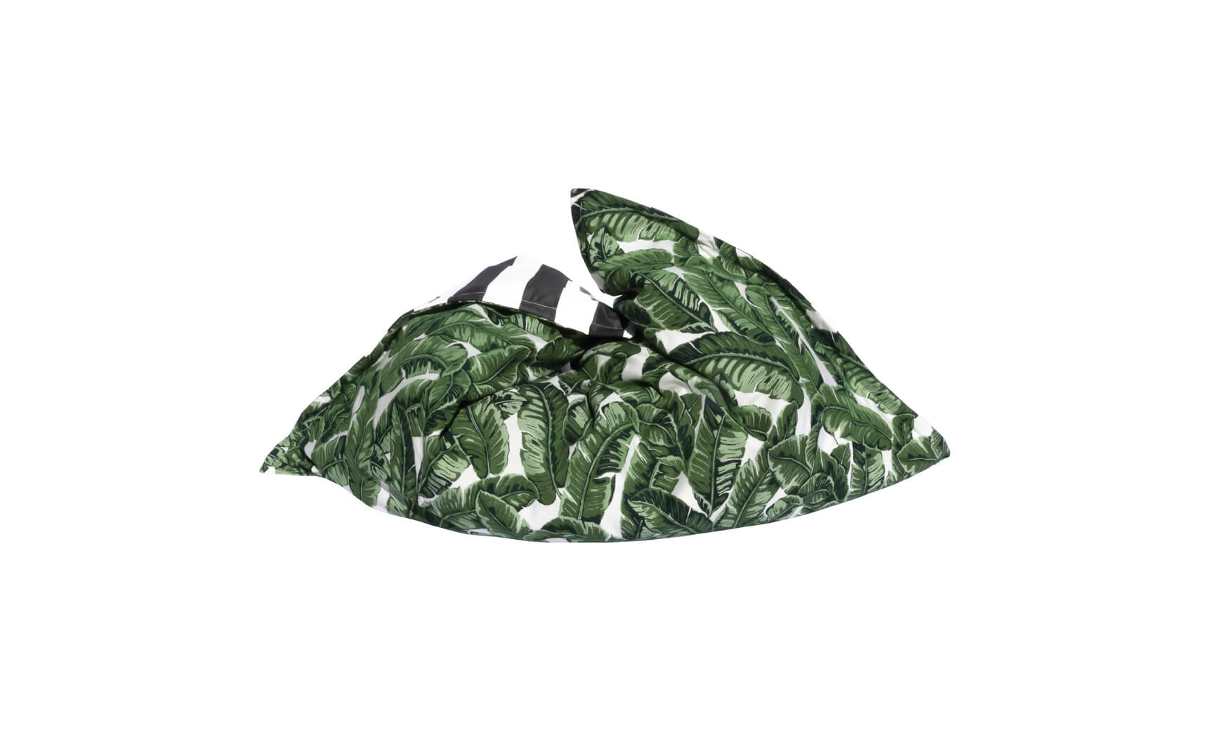 The Laze Pillow by Ledge Lounger is a green bean bag with large leafy tropical plant patterns on a white background. Its relaxed, tilted shape makes it perfect for outdoor comfort and as a floating pool pillow, adding tropical flair to any setting.