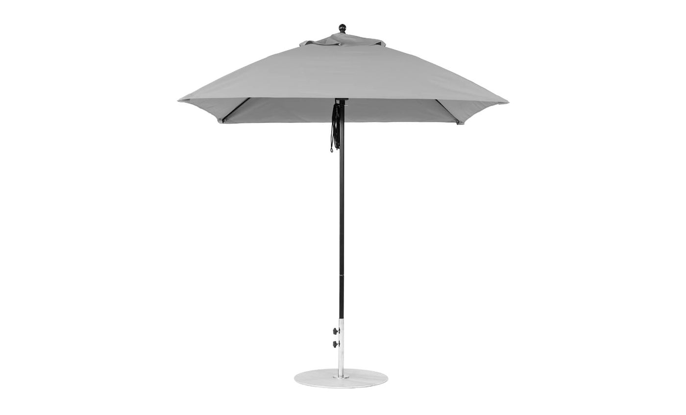 The Essential Fiberglass Umbrella by Ledge Lounger has a sleek, minimalist design with a square canopy made from marine-grade fabrics. It features a straight pole and a flat base, showcased fully open against a plain white background.