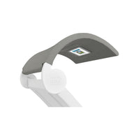 The Signature Chaise Shade by Ledge Lounger is a modern grey fabric book holder on a white stand, perfect for displaying an open book or tablet. Its curved design includes an image of an open book and offers a unique media viewing window for an enhanced reading experience.