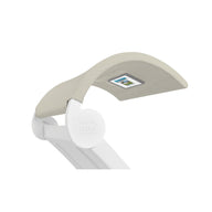 The Signature Chaise Shade by Ledge Lounger is a modern, white desk lamp with an adjustable arm and beige fabric-covered head. It features a media viewing window and a small digital screen in the head, while the LEDCORE logo stands out prominently on its joint.