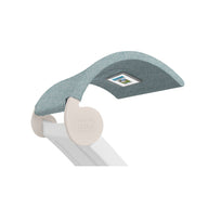 The Signature Chaise Shade by Ledge Lounger has a modern teal upholstery headrest with an integrated media viewing window, supported by a sleek white structure. It combines comfort and style, featuring LEDGE LOUNGER embossed on the side.