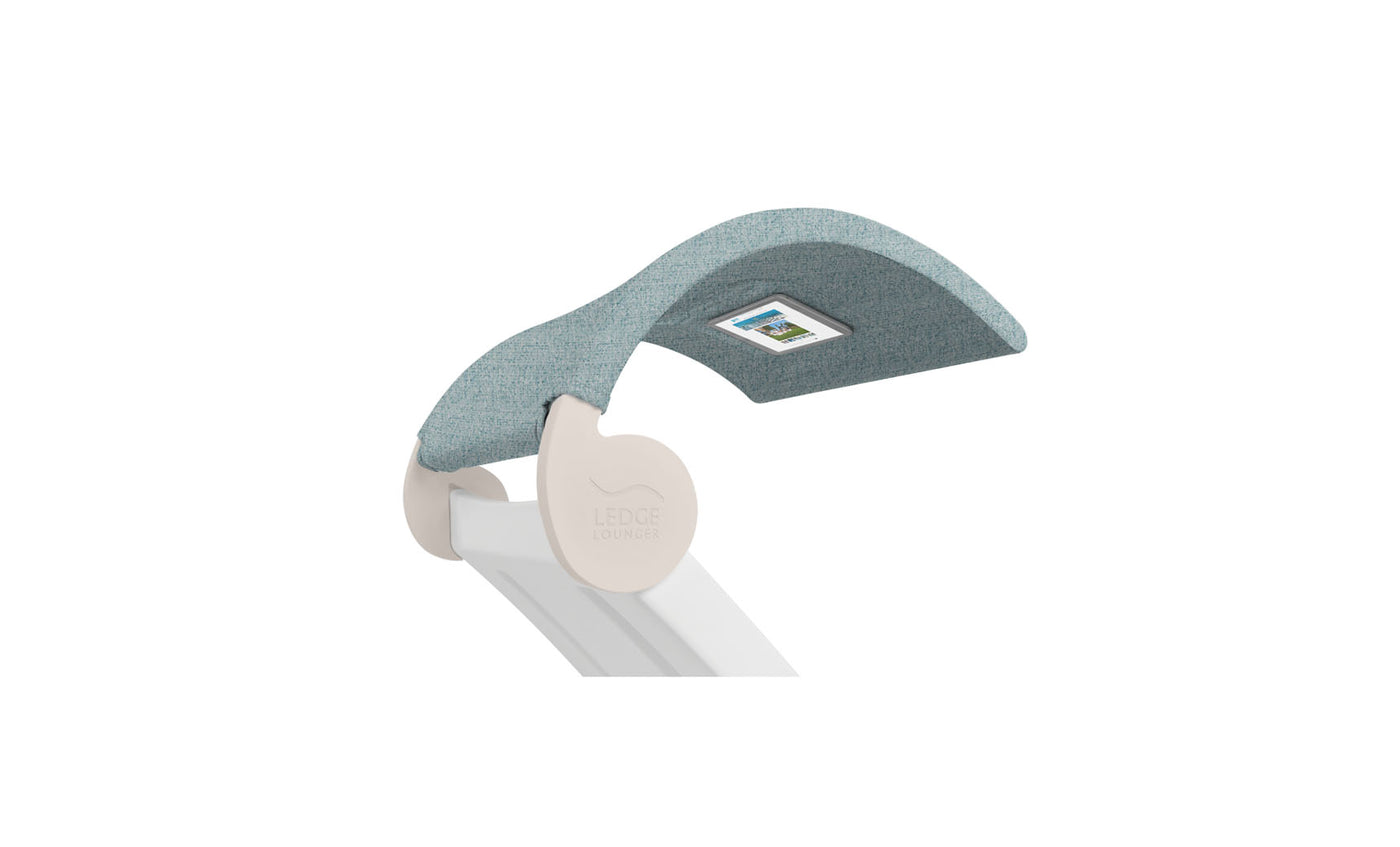 The Signature Chaise Shade by Ledge Lounger has a modern teal upholstery headrest with an integrated media viewing window, supported by a sleek white structure. It combines comfort and style, featuring LEDGE LOUNGER embossed on the side.