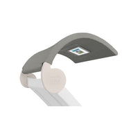 The Signature Chaise Shade by Ledge Lounger is a modern ergonomic desk chair headrest in gray fabric, featuring a small rectangular media viewing window. It has a white connecting arm with a subtle logo imprint on its circular joint.