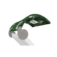 The Signature Chaise Shade from Ledge Lounger is a modern massage table with a green tropical leaf-patterned headrest and digital screen for relaxing views, complemented by a sleek white frame for a contemporary, clean aesthetic.