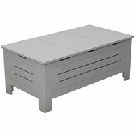 The Ledge Lounger Mainstay Storage Coffee Table is a white, rectangular wooden bench featuring a slatted front design. Ideal for outdoor living spaces, it offers seating and ample storage. With its flat top and short legs, its perfect as both a storage coffee table and seating solution.