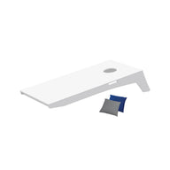 The Ledge Lounger Cornhole set includes a white board with a top hole and two bean bags in blue and gray, elegantly angled against a plain white backdrop, ready for play anywhere.