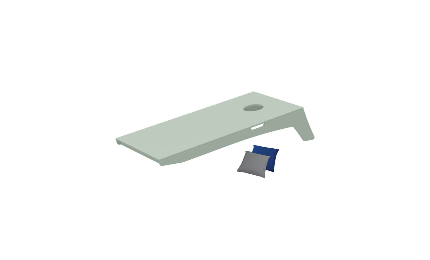 The image shows a light green Cornhole board by Ledge Lounger, featuring a hole on the upper right and angled for an engaging Bean Bag Toss. A blue and gray bean bag rest beside it, part of this portable set.