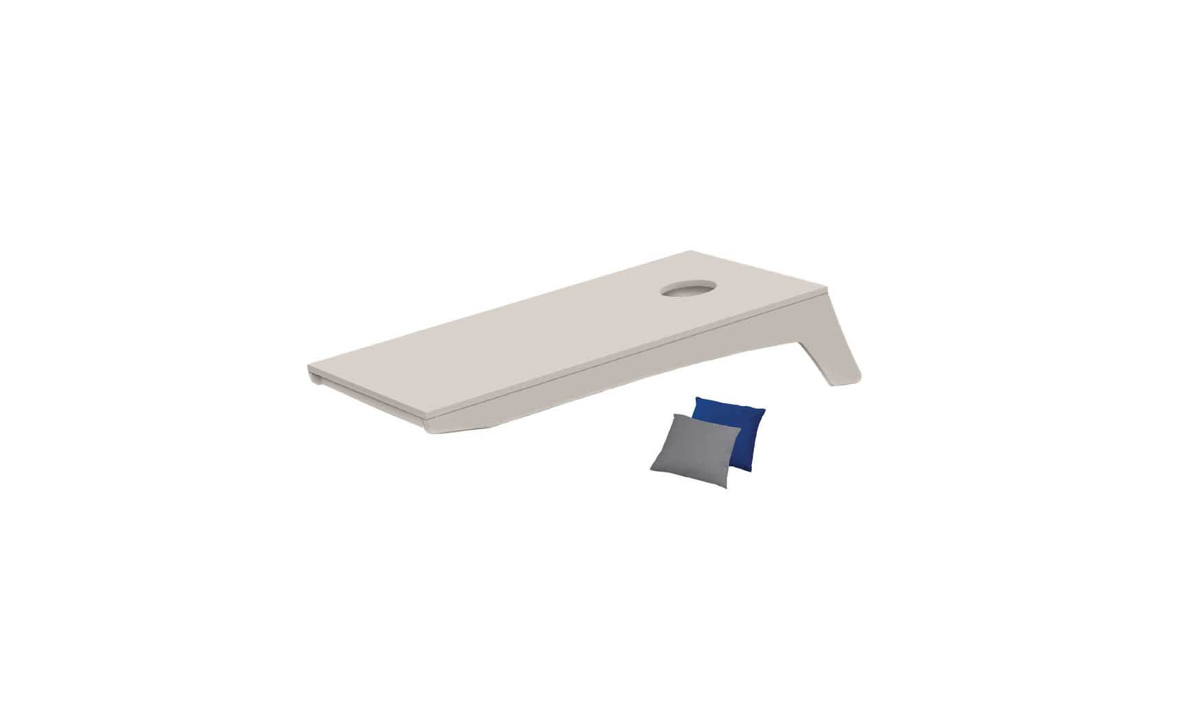 The Ledge Lounger Cornhole set includes a minimalist board design with an angled setup and a hole near one end, accompanied by two bean bags in blue and gray ready for tossing.