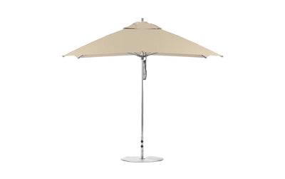 The Ledge Lounger Essential Fiberglass Umbrella - 8.5 Rectangle Pulley, viewed from the side, features a beige canopy with a silver pole and round base. Its minimalist design is crafted from wind-resistant, marine-grade fabrics, ideal for outdoor settings.