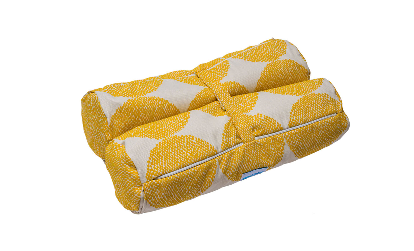 The yellow and white rectangular Ledge Lounger Laze Hammock cushion has a dot pattern, two cylindrical rolls, and a central fabric band, making it perfect for outdoor adventures and cozying up in a hammock.