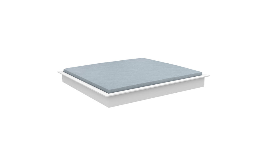 The Echo Sunbed by Ledge Lounger, highlighted from a slight angle against a white backdrop, showcases a minimalist white platform paired with a light blue mattress. Its modern design emphasizes simplicity and functionality, perfect for adding elegance indoors or transforming outdoor spaces into relaxation havens.