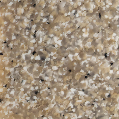 Close-up of a speckled surface with a mix of beige, white, and black spots, resembling a terrazzo or granite pattern. The uneven distribution of colors creates a textured and natural appearance.