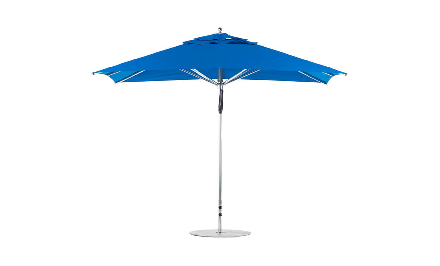 The 8.5 rectangular Premier Aluminum Umbrella by Ledge Lounger, featuring a blue canopy and metal pole with a round base, is fully open. Its simple design with a slight ruffle at the top offers shade and shelter, set against a white background.