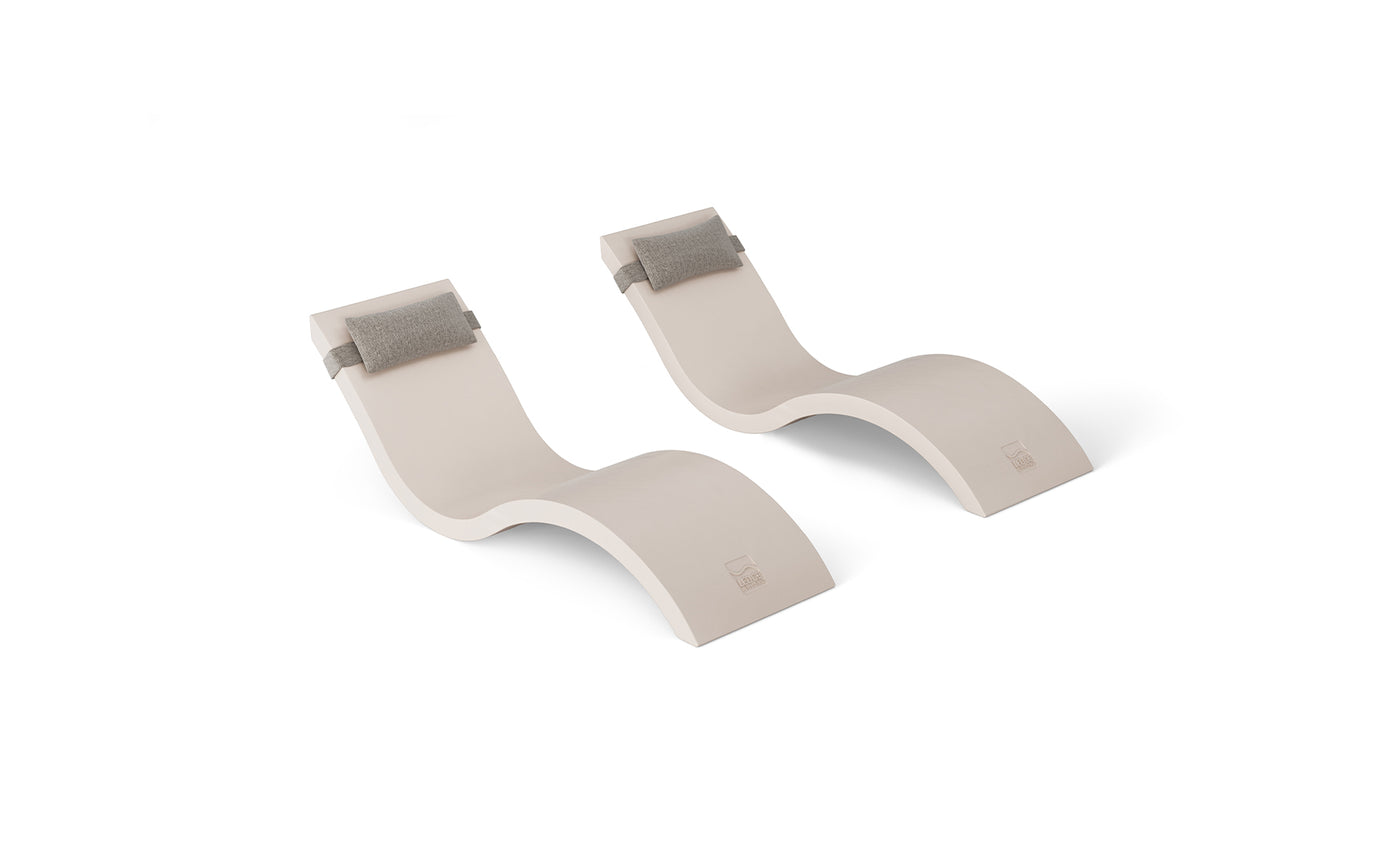 The Outdoor Escape In-Pool Furniture Bundle by Ledge Lounger features two identical beige, S-shaped chaise lounges with gray headrest pillows on a white background, showcasing a modern, minimalist design ideal for outdoor settings.