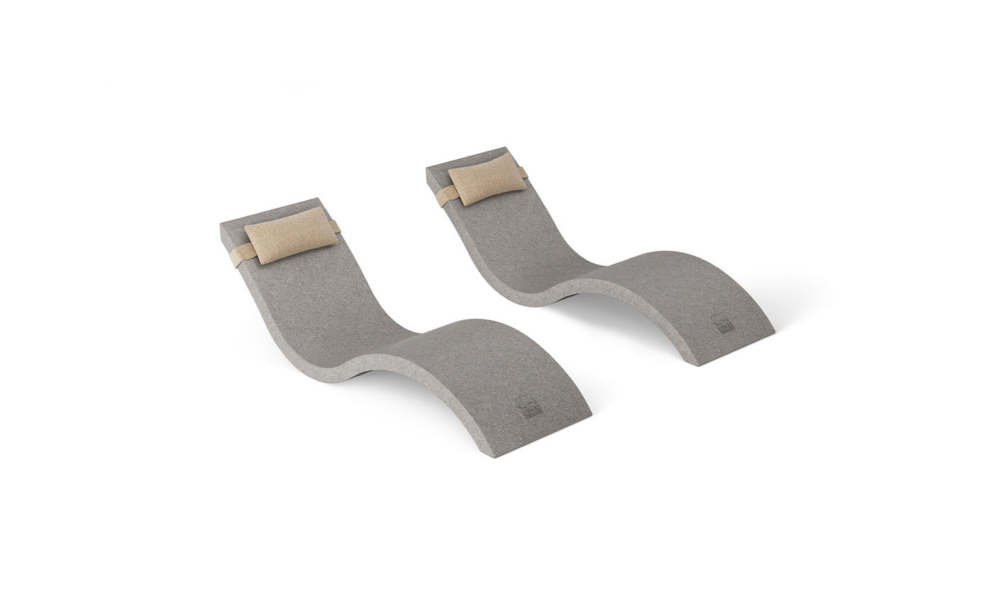 The Ledge Lounger Outdoor Escape In-Pool Furniture Bundle features two wave-shaped chaise lounges with light beige headrest pillows, smooth curves, and gray upholstery on a white background—a modern, minimalist addition to your outdoor ensemble.