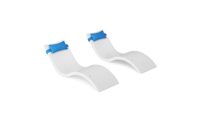The Ledge Lounger Signature Chaise and Headrest Pillow In-Pool Set features two modern white loungers with curved designs and bright blue pillows, creating a stylish outdoor furniture statement against a white background.