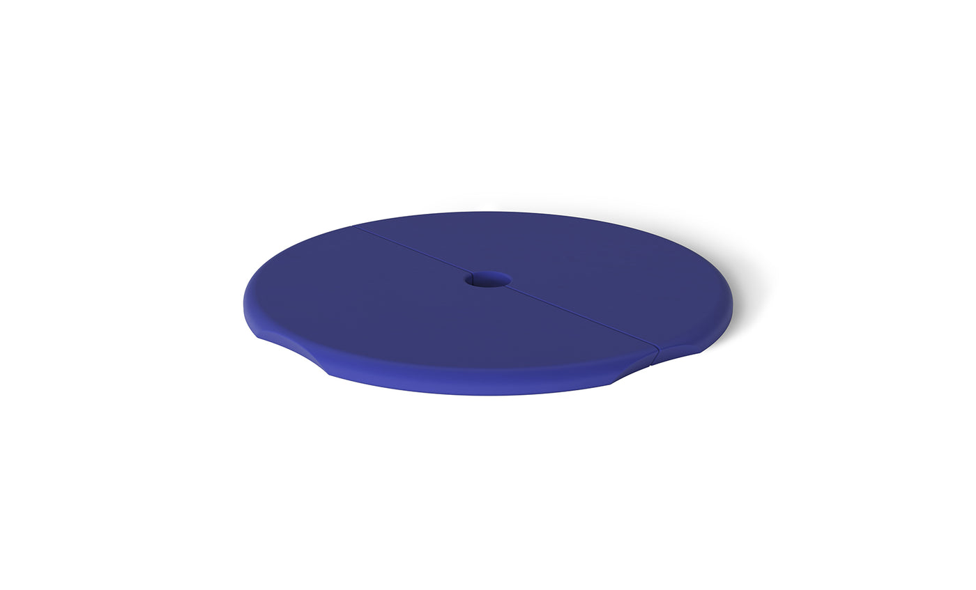 The Ledge Lounger Signature Side Table Lid features a smooth, round blue disc design with a slit from center to edge and a central hole for an umbrella pole, plus subtly raised edges.