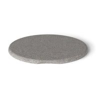 The Signature Side Table Lid by Ledge Lounger is a speckled gray, round stone-like surface with a smooth texture and an indented edge, adding character to outdoor spaces while casting a faint shadow on the white background.