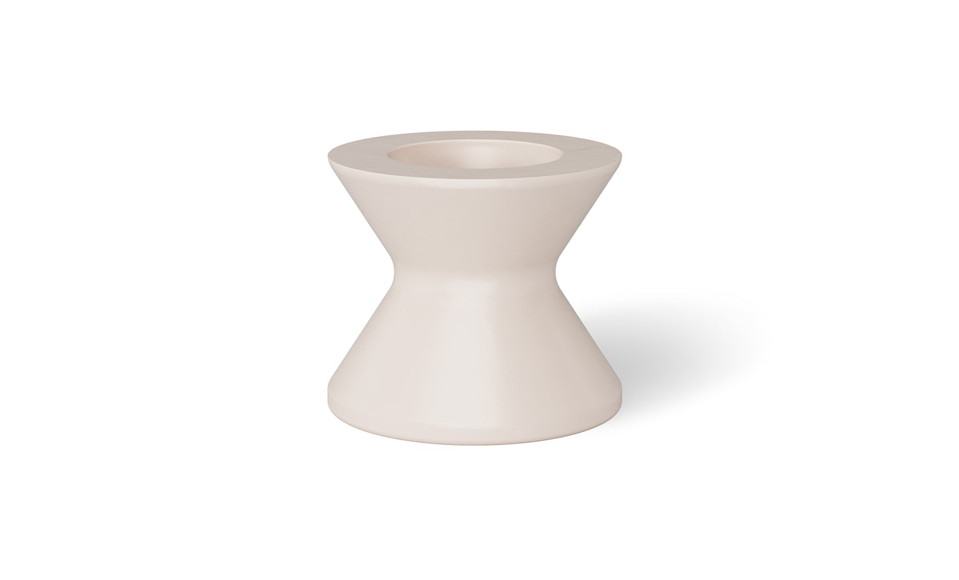 A white, hourglass-shaped vase with a narrow center and wide opening elegantly sits on the Signature Tall Ice Bin Side Table by Ledge Lounger, its matte finish catching the light and casting a shadow to the right.