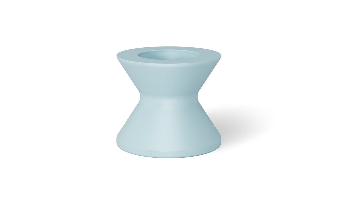 The Signature Tall Ice Bin Side Table by Ledge Lounger is a light blue, hourglass-shaped ceramic stool with a smooth surface, wider top and base tapering elegantly toward the center, and featuring a small circular indentation on top.