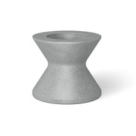 A small, hourglass-shaped gray object with a hollow top resembles an umbrella base. Its smooth surface and symmetrical design remind one of an industrial component. Shadows imply placement on a light surface, akin to the Signature Tall Ice Bin Side Table by Ledge Lounger.