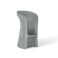 Introducing the Signature Barstool Bar Height by Ledge Lounger: a modern minimalist gray stool with a high backrest, cylindrical form, and stone-like texture. Its widened base and integrated footrest ensure support, while the curved seat is perfect for poolside seating during outdoor entertaining.