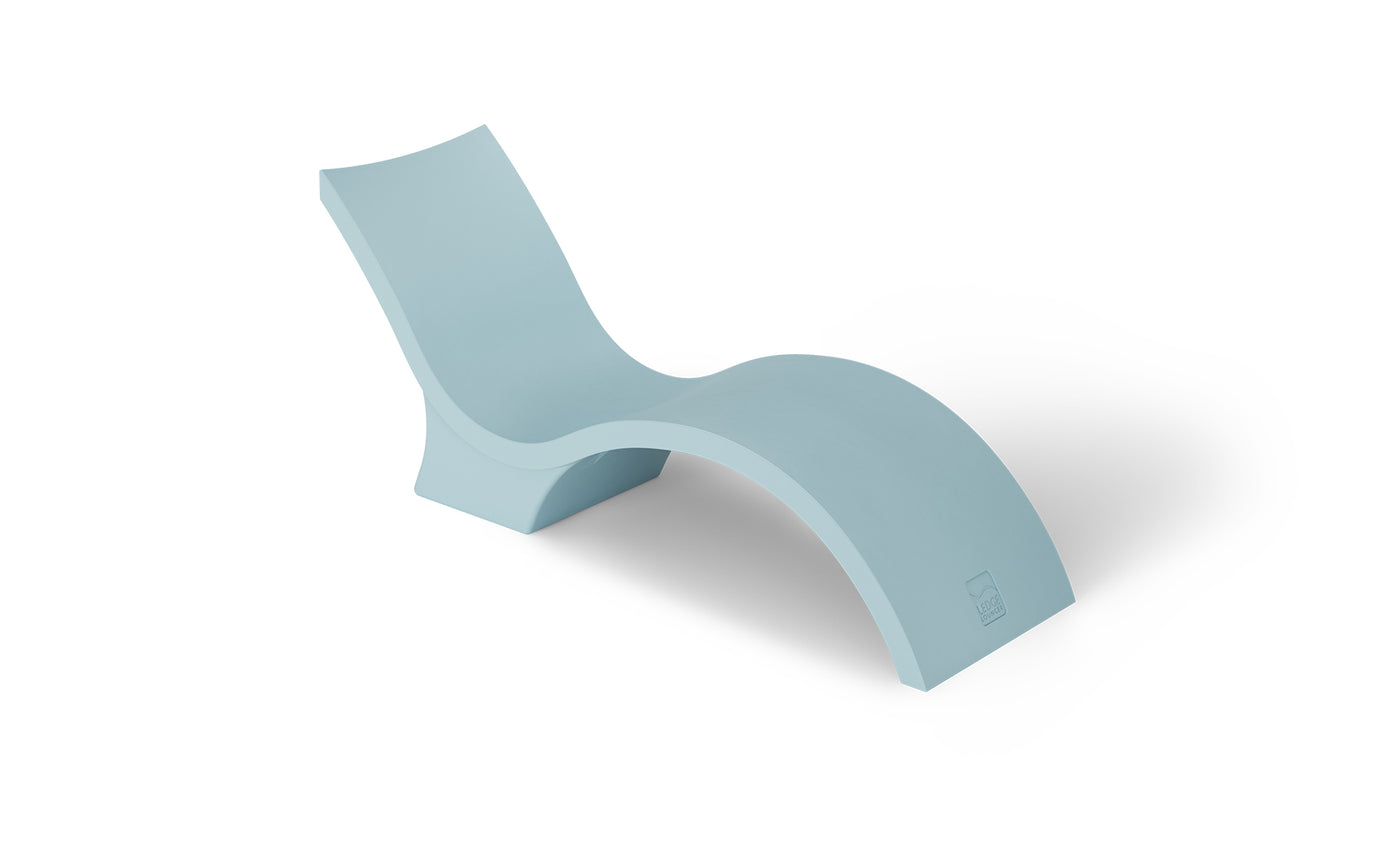 The Signature Chaise Deep by Ledge Lounger is a light blue, modern chaise lounge with a smooth, curved design and an elevated backrest. Perfect for a sun shelf or tanning ledge, its showcased against a white background for ultimate relaxation.