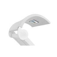 The Signature Chaise Shade by Ledge Lounger is a modern, white desk lamp with an adjustable arm that enhances your media viewing. It features a curved rectangular light head with a digital display and Ledge Lounger proudly displayed on the hinge against a plain white background.