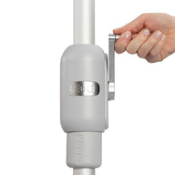 A person grips a metallic lever on a gray, cylindrical device from the 6.5 Square Signature 360° Tilt Umbrella by Ledge Lounger. Its rustproof frame, engraved with the brand name, stands out against the plain white background, highlighting its sleek design.