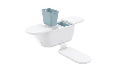The PartyPad - White by Ledge Lounger is a modular shower caddy in white and light blue, featuring a central compartment, two folding shelves (one folded down), and a perforated insert for ventilation.