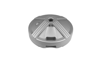The Ledge Lounger Resin Coated Concrete Umbrella Base features a round, grey plastic design with geometric grooves and a central hole, perfect for center pole umbrellas. Its smooth surface has a raised circular section and side opening to enhance outdoor dining experiences.