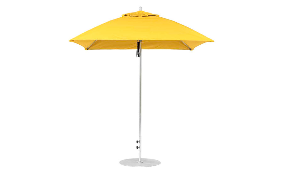 The closed yellow Essential Fiberglass Umbrella - 7.5 Square Pulley by Ledge Lounger stands on a sleek metallic pole with a round base. Built from marine-grade fabrics, its vibrant canopy is neatly folded, ideal for both in-pool and on-deck use.