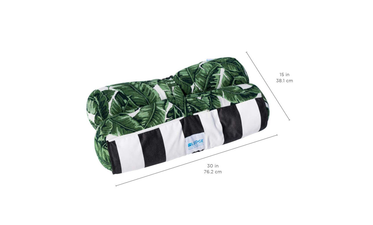 The Ledge Lounger Laze Hammock features a neatly rolled towel with a green leaf pattern, accented by white and black stripes at the base. Ideal for outdoor adventures, it measures 30 (76.2 cm) in width and 15 (38.1 cm) in height.