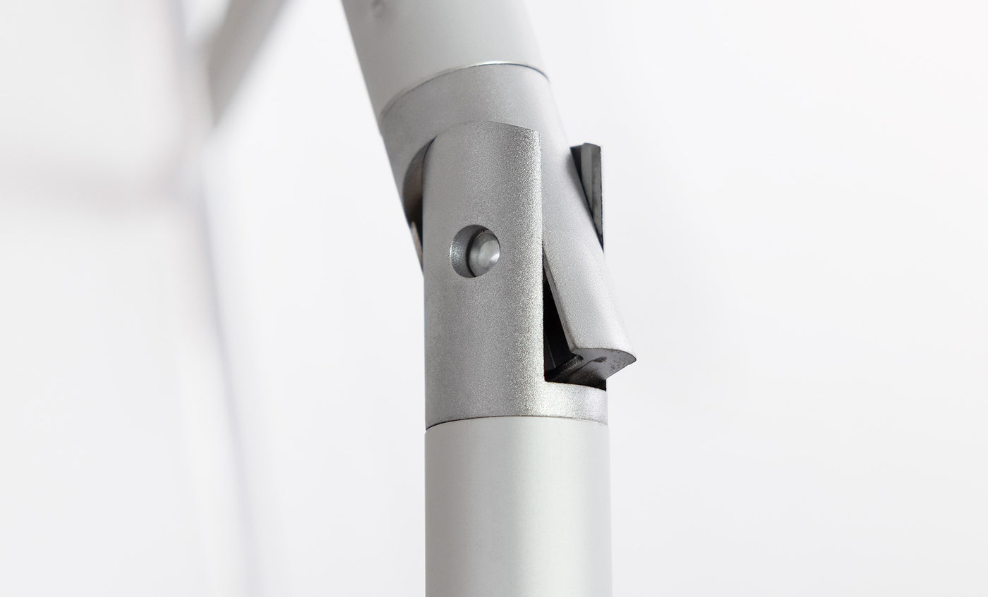 Close-up of a silver-gray metallic hinge with cylindrical components and a pivot mechanism, designed for the 7.5 Octagon Signature 360° Tilt Umbrella by Ledge Lounger, set against a plain white background.