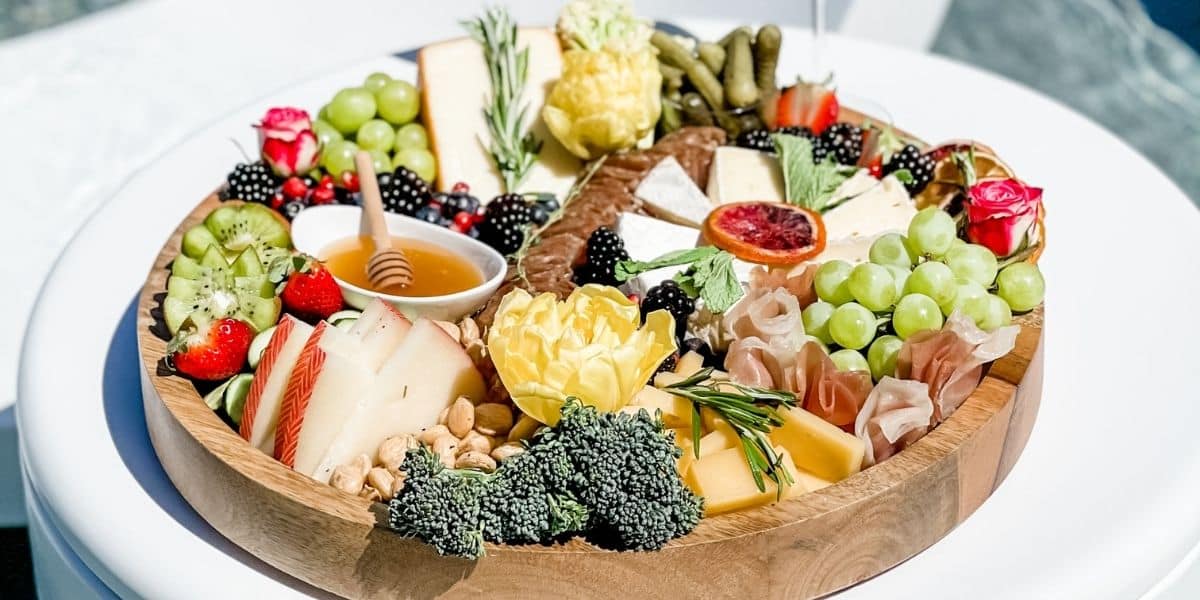 Poolside charcuterie board sitting on Ledge in-pool side table