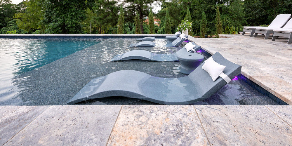 Ledge gray in-pool chaise loungers in a pool