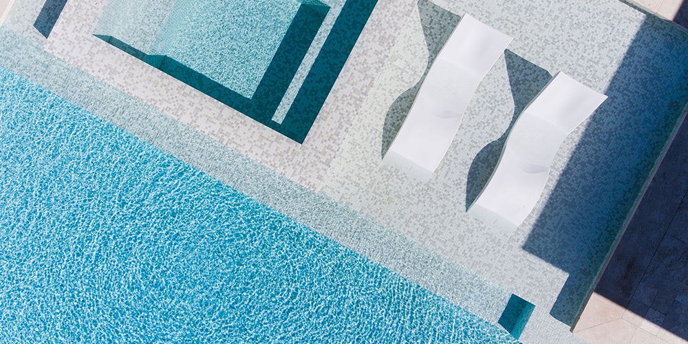 Pool ledge with white in-pool chaise loungers