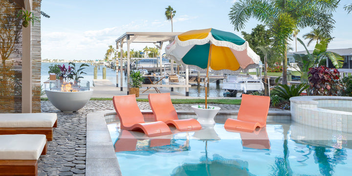 Pool ledge with in-pool chairs, side table, and umbrella