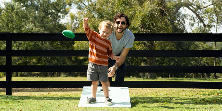 Dad and son playing Cornhole outside
