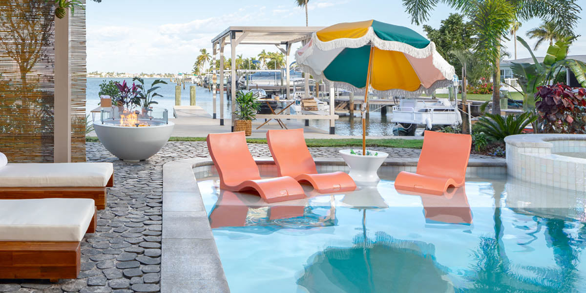 Coral Signature Chairs by Ledge with a side table umbrella stand in the pool