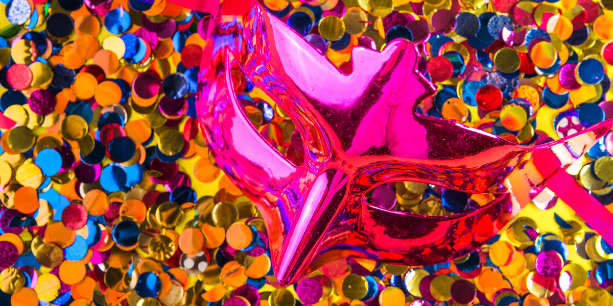 Pink carnival mask over confetti