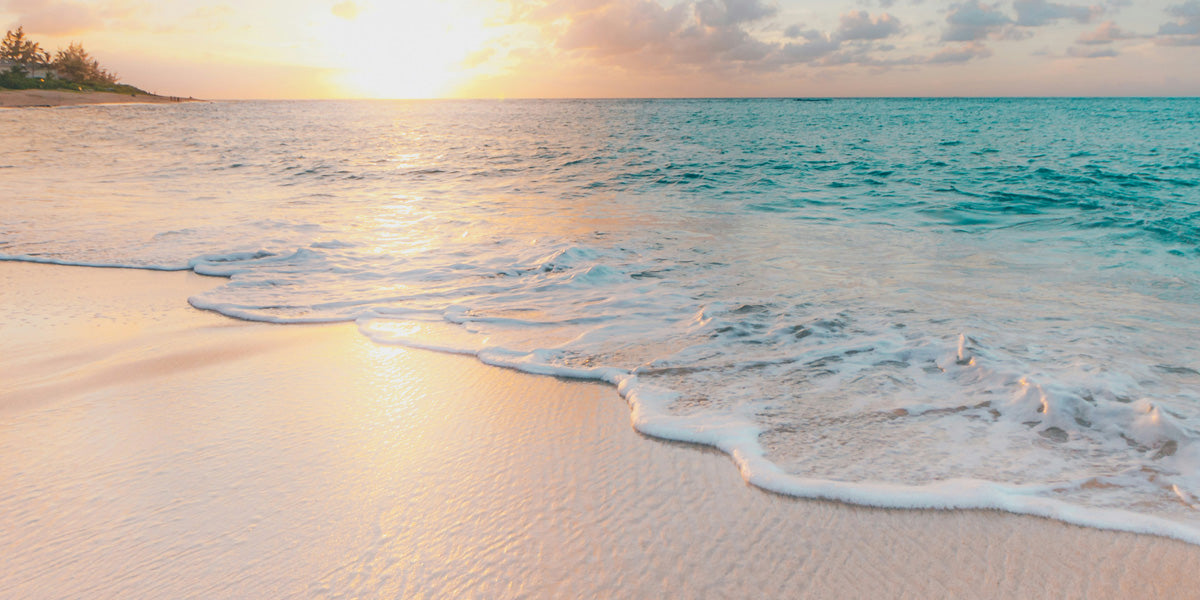 Beach at sunrise, waves coursing across sand