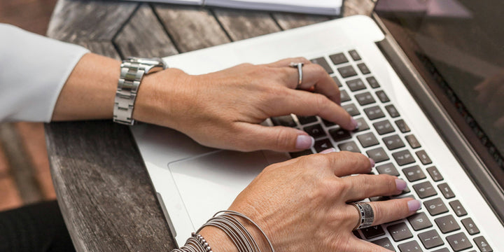 Hands typing on a computer