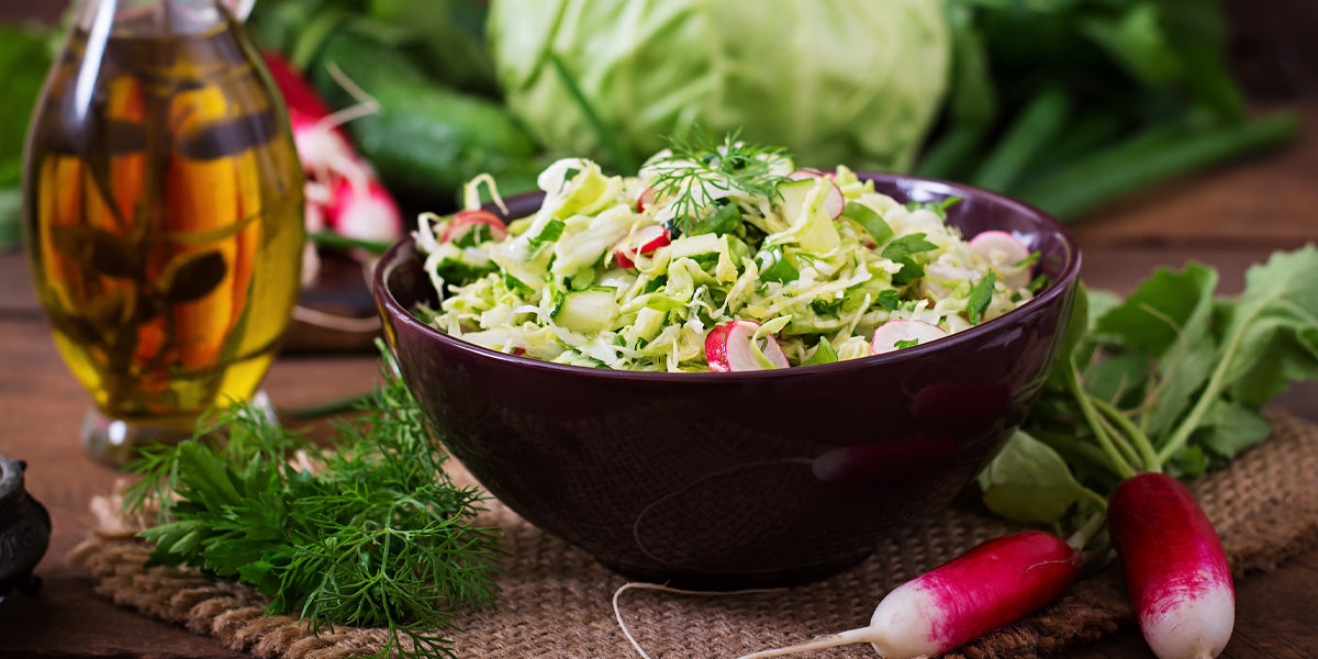 Salad bowl prepared with radish, herbs, and olive oil