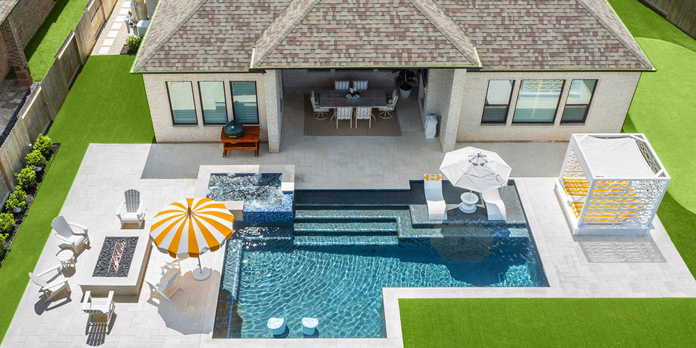 Aerial view of a backyard with a pool and high-end furniture