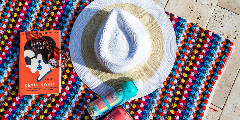 Hat, sunscreen, and book on outdoor rug